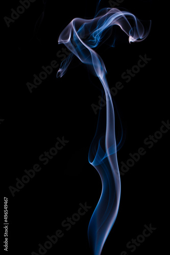 Blue and grey smoke patterns from incense stick and cigarette smoke taken in a studio on a black backdrop beautifully isolated 