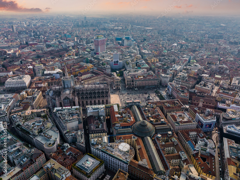 Obraz premium Aerial view of Piazza Duomo in front of the gothic cathedral in the center. Drone view of the gallery and rooftops during the day. Milan. Italy,
