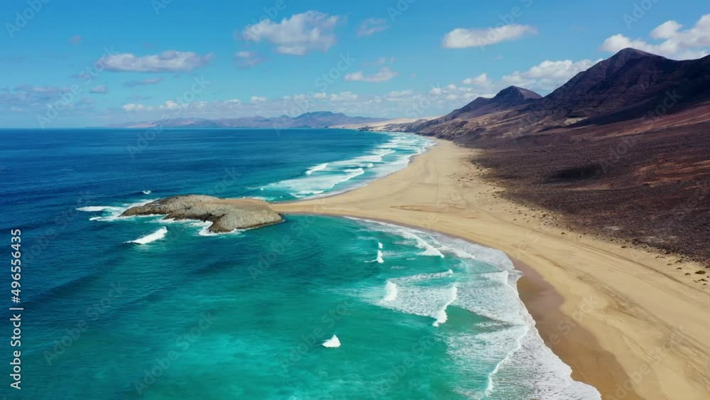 Amazing Cofete beach with endless horizon. Volcanic hills in the background and Atlantic Ocean. Cofete beach, Fuerteventura, Canary Islands, Spain. Playa de Cofete, Fuerteventura, Canary Islands.