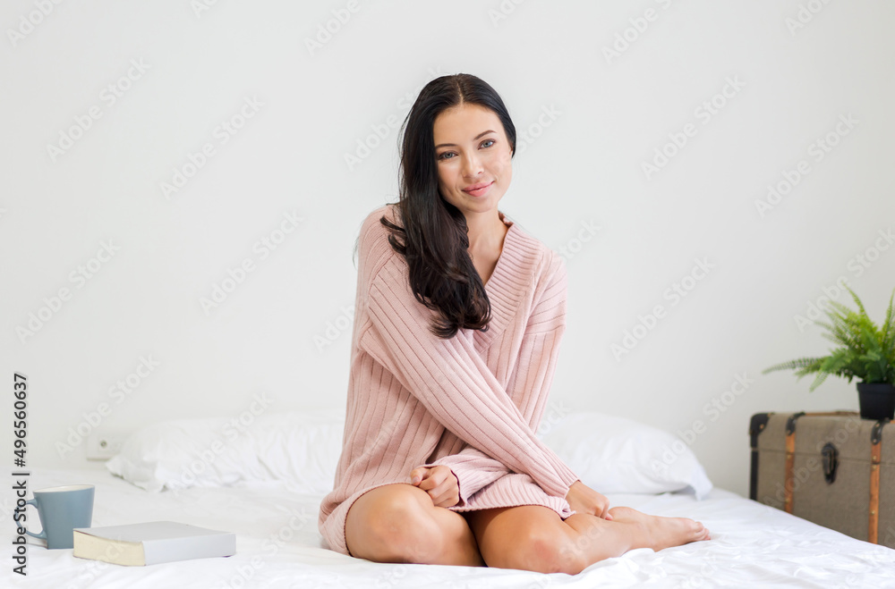 Smiling of cheerful beautiful pretty woman clean fresh healthy white skin posing in warm knitted pink clothes.Girl felling relaxing and enjoy time on the bed at home Smiling of cheerful beautiful pretty woman clean fresh healthy white skin posing in warm knitted pink clothes.Girl felling relaxing and enjoy time on the bed at home