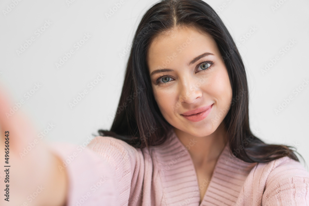 Portrait of smiling cheerful beautiful pretty asian woman clean fresh healthy white skin posing smile look at camera making live selfie on smartphone on the bed at home Portrait of smiling cheerful beautiful pretty asian woman clean fresh healthy white skin posing smile look at camera making live selfie on smartphone on the bed at home