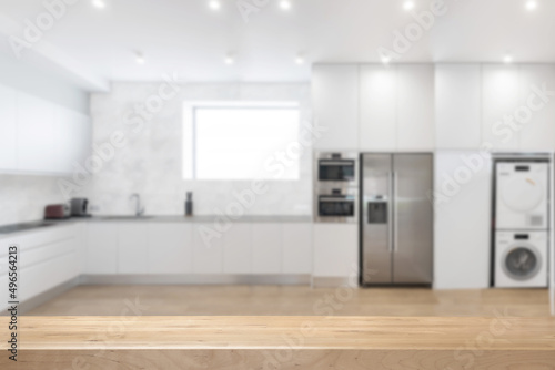 White kitchen interior background with appliances and selective focus on wooden surface