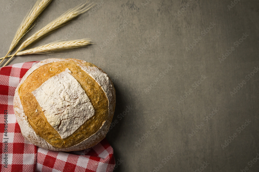 Beautiful Sourdough bread on gray background with dried wheat flower Beautiful Sourdough bread on gray background with dried wheat flower