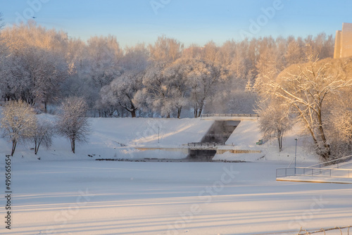 beautiful city park covered with snow blanket on winter frosty morning
