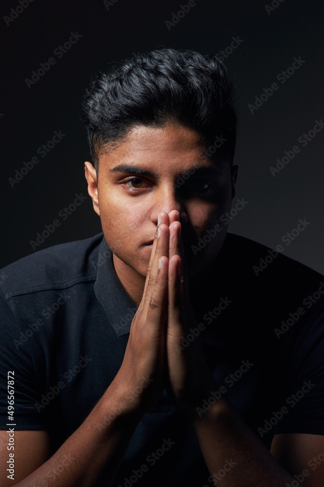 Being yourself is all about knowing what you believe in. Studio shot of a handsome young man sitting against a black background. Being yourself is all about knowing what you believe in. Studio shot of a handsome young man sitting against a black background.