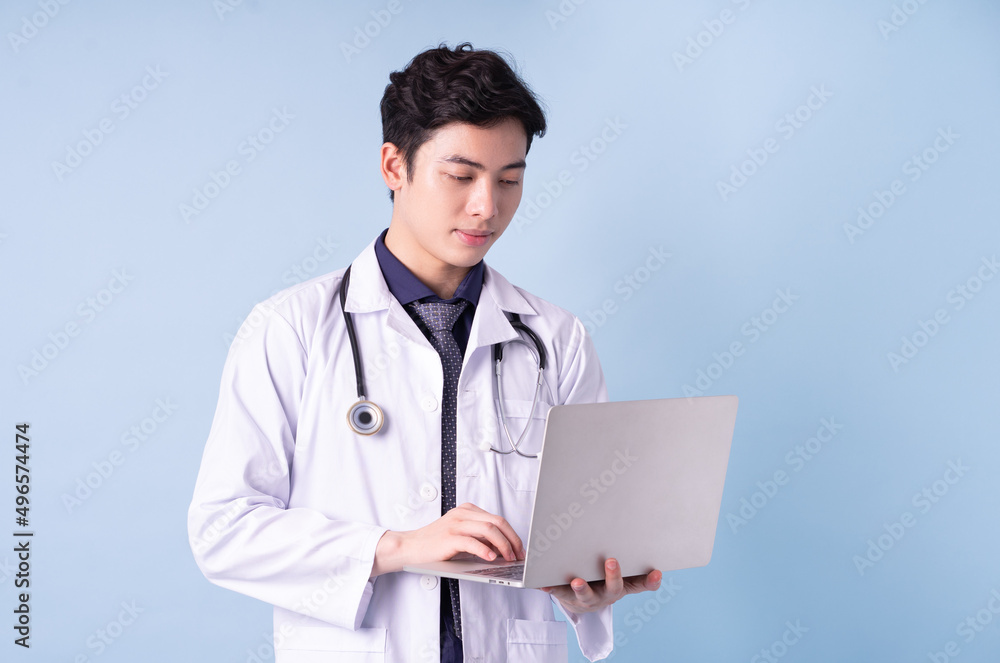 Portrait of young Asian male doctor on blue background Portrait of young Asian male doctor on blue background