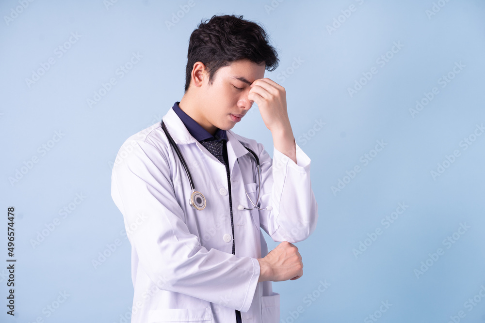 Portrait of young Asian male doctor on blue background Portrait of young Asian male doctor on blue background