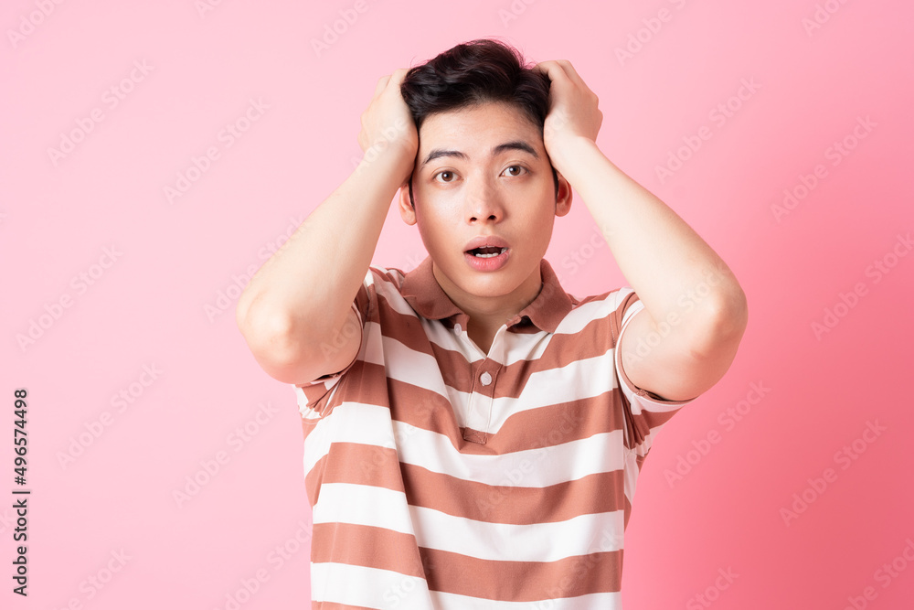 Young Asian man posing on pink background Young Asian man posing on pink background