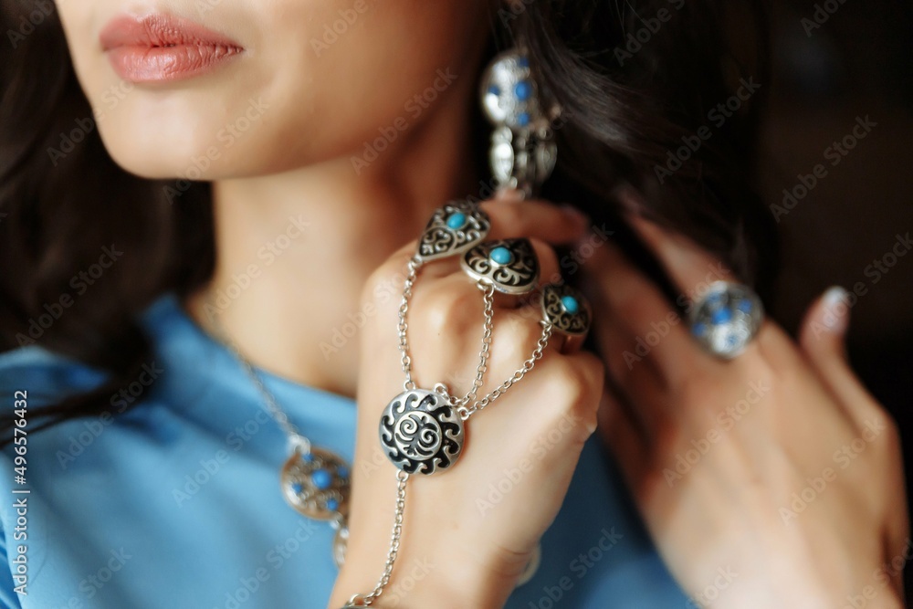 Kazakh national jewelry earrings, bracelet, ring on a woman