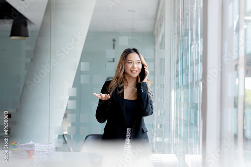 Asian woman talking on the phone, she is a salesperson in a startup company, she is calling customers to sell products and promotions. Concept of selling products through telephone channels.