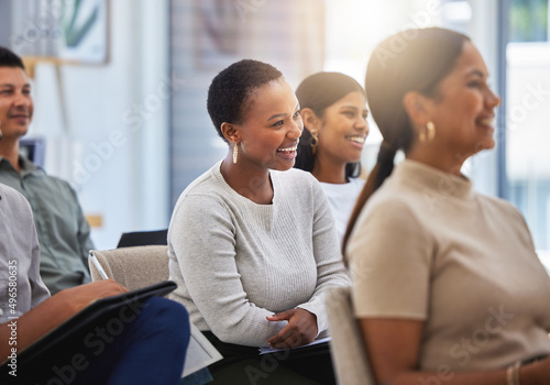 The journey towards success. Shot of a group of employees laughing during a meeting at work in a modern office.