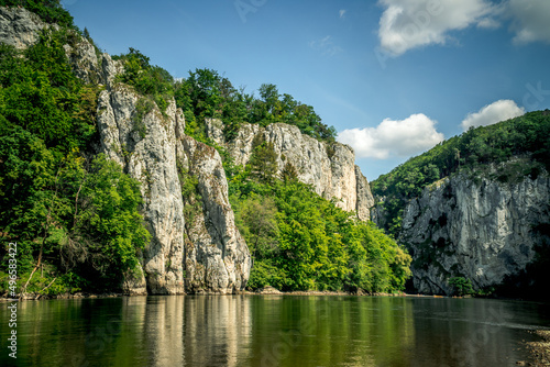 Rocks of the Danube Gorge with green forest  blue sky  water and beach of the Danube. Danube Gorge in Bavaria Germany.