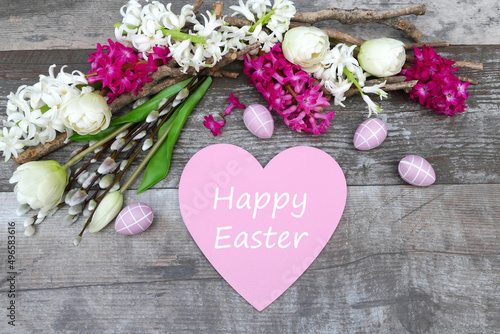 Flower arrangement with Easter decorations and the lettering Happy Easter on a heart.