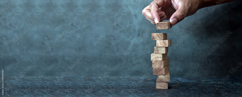 Hand prevent wooden block stack in tower stair step concept of prevent collapse or crash of financial business and risk management or strategic planning and insurance. - obrazy, fototapety, plakaty 