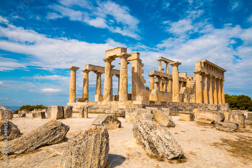 View on ruins Temple of Aphaea, Aegina, Greece with clouds and sun rays in the background photo
