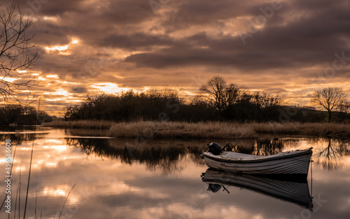 Sunset reflecting over the River Dee in Winter, with a boat in the river