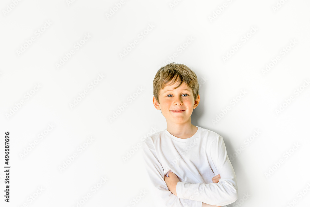 A second grader in an elementary school looks at the camera. Portrait of white eight year old boy with copy space. Bright children's emotions A second grader in an elementary school looks at the camera. Portrait of white eight year old boy with copy space. Bright children's emotions