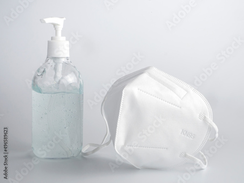 KN95 medical or surgical mask and alcohol gel in bottle on white background.medical mask used to cover the mouth and nose to prevent germs from entering the body.