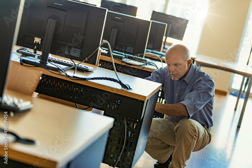 Senior Technician engaged in computer in a large room