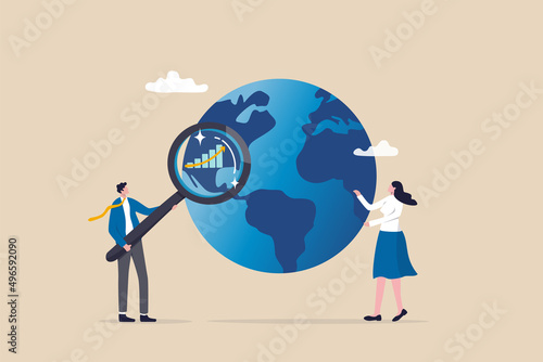 World economic analysis, global investment or international business opportunity research, forecast and analyze financial information concept, businessman with magnifier on globe with chart and graph.