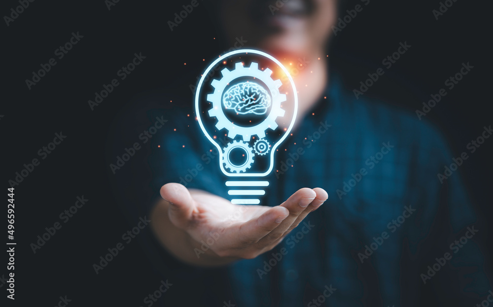 © Dilok - Businessman holding virtual lightbulb with mechanical gear and brain for creative thinking idea and innovation concept.