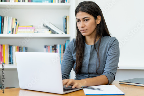 South american business trainee working at computer