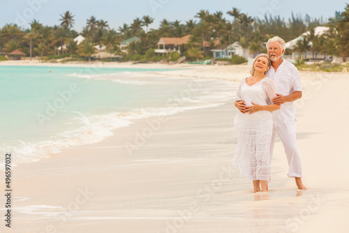 Retired Caucasian couple in white clothes on a Caribbean beach