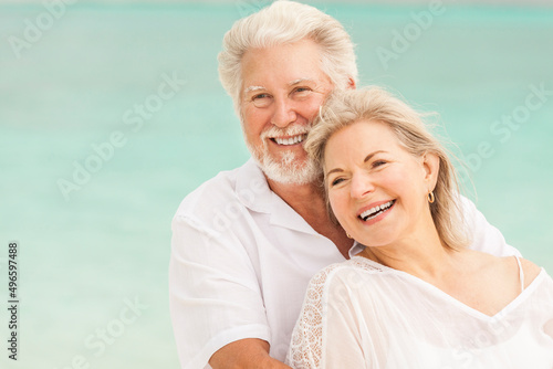 Happy mature Caucasian couple in white outdoors together on tropical beach © Spotmatik
