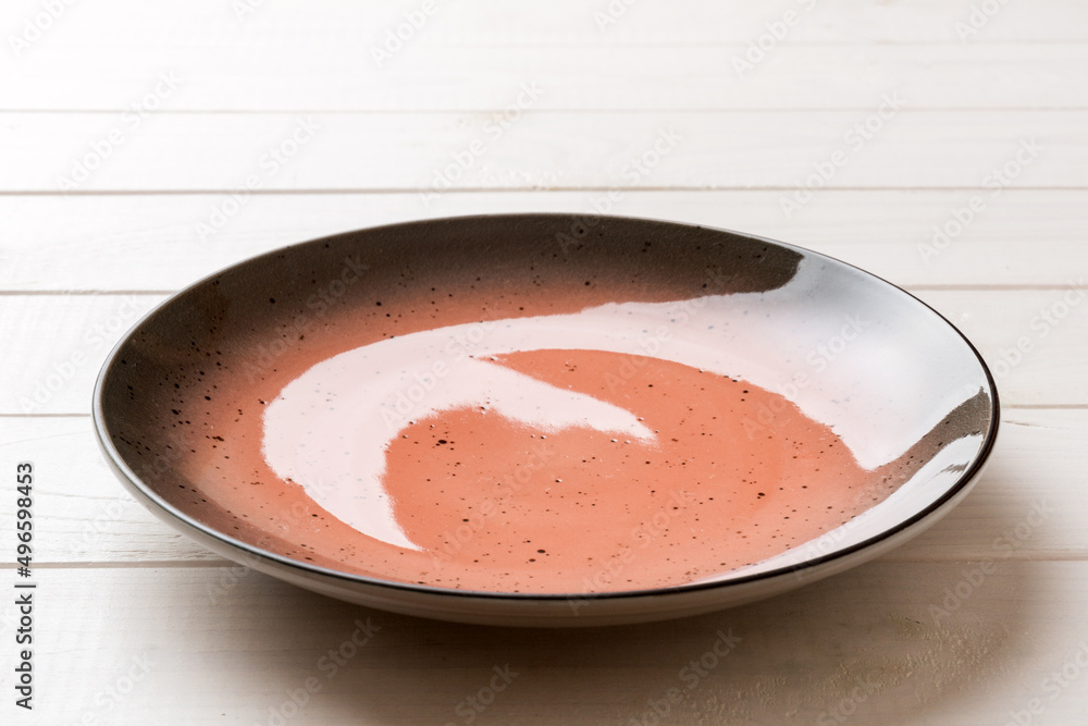 Perspective view of empty red plate on wooden background. Empty space for your design Perspective view of empty red plate on wooden background. Empty space for your design