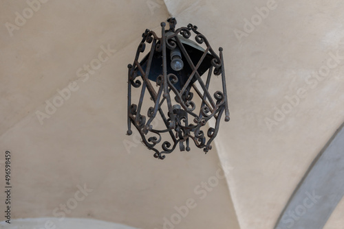 old iron chandelier on the ceiling on the ceiling of ancient architecture