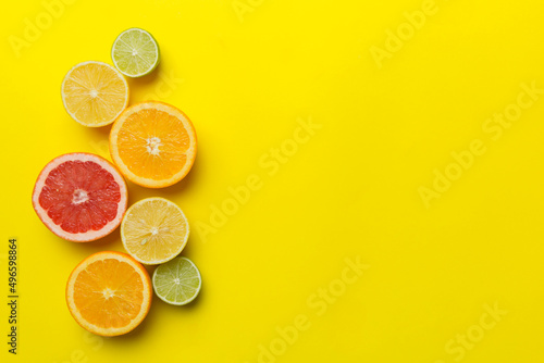 Fruit background. Colorful fresh fruits on colored table. Orange, lemon, grapefruit Space for text healthy concept. Flat lay, top view, copy space