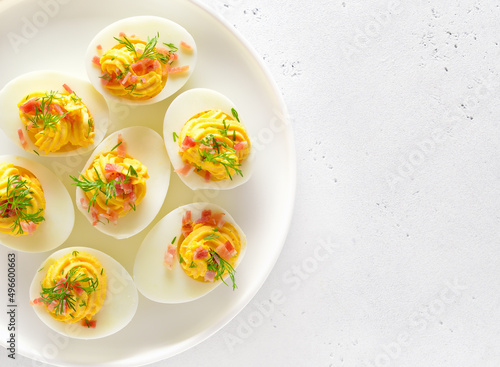 Stuffed eggs with egg yolk, bacon, mustard on plate