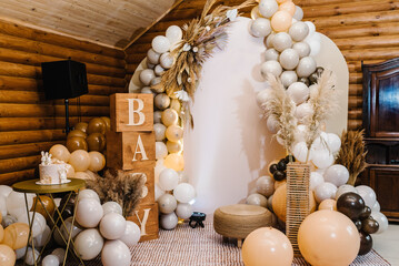 Birthday decorations - balloons, garland and decor for little baby party on a wall background. Celebration baptism concept. Baby text. Trendy Cake.