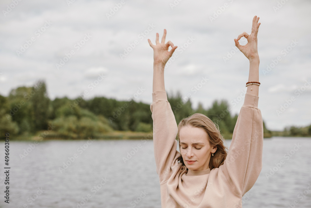 Young woman meditating outdoors in the fresh morning. Self-analysis and soul-searching concept. Young woman meditating outdoors in the fresh morning. Self-analysis and soul-searching concept.