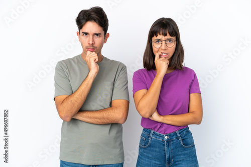 Young couple isolated on isolated white background having doubts while looking up