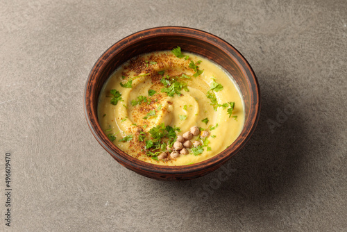 A bowl with hummus, fava or vegetable caviar. Close-up on a gray background. photo