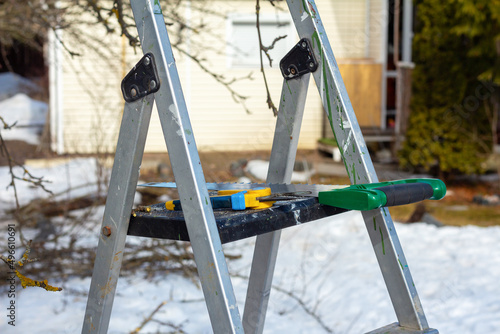 Hand saw and garden pruner on a ladder