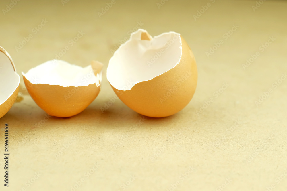 Eggshell broken into two pieces on table Eggshell broken into two pieces on table
