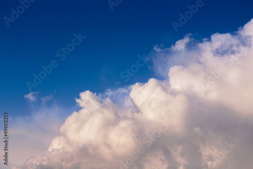 Airy white clouds on clear blue sky © Karamelity
