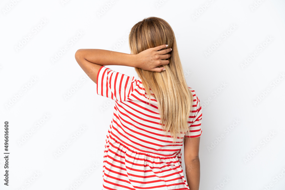 Blonde Uruguayan girl isolated on white background in back position and thinking Blonde Uruguayan girl isolated on white background in back position and thinking