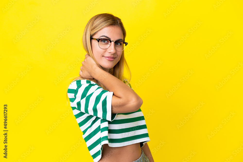 Blonde Uruguayan girl isolated on yellow background laughing