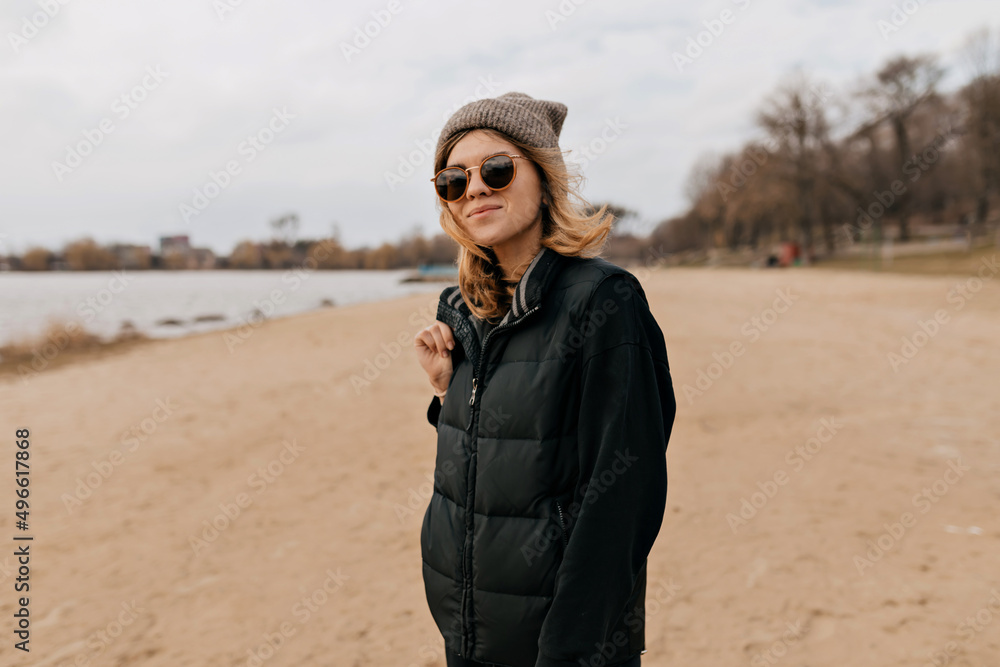 Happy short-haired woman enjoying windy sunny day on the beach. Outdoor shot of charming brunette girl traveling Happy short-haired woman enjoying windy sunny day on the beach. Outdoor shot of charming brunette girl traveling