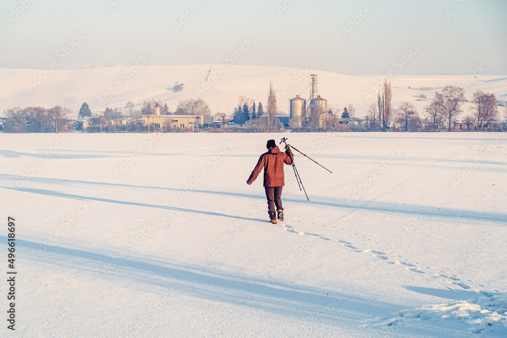 photographer with a tripod in the winter landscape.