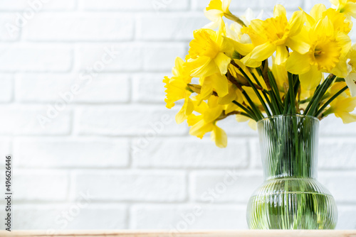 bouquet of yellow daffodils in a vase on a bright background, spring flowers