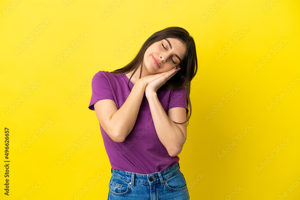 Young caucasian woman isolated on yellow background making sleep gesture in dorable expression Young caucasian woman isolated on yellow background making sleep gesture in dorable expression
