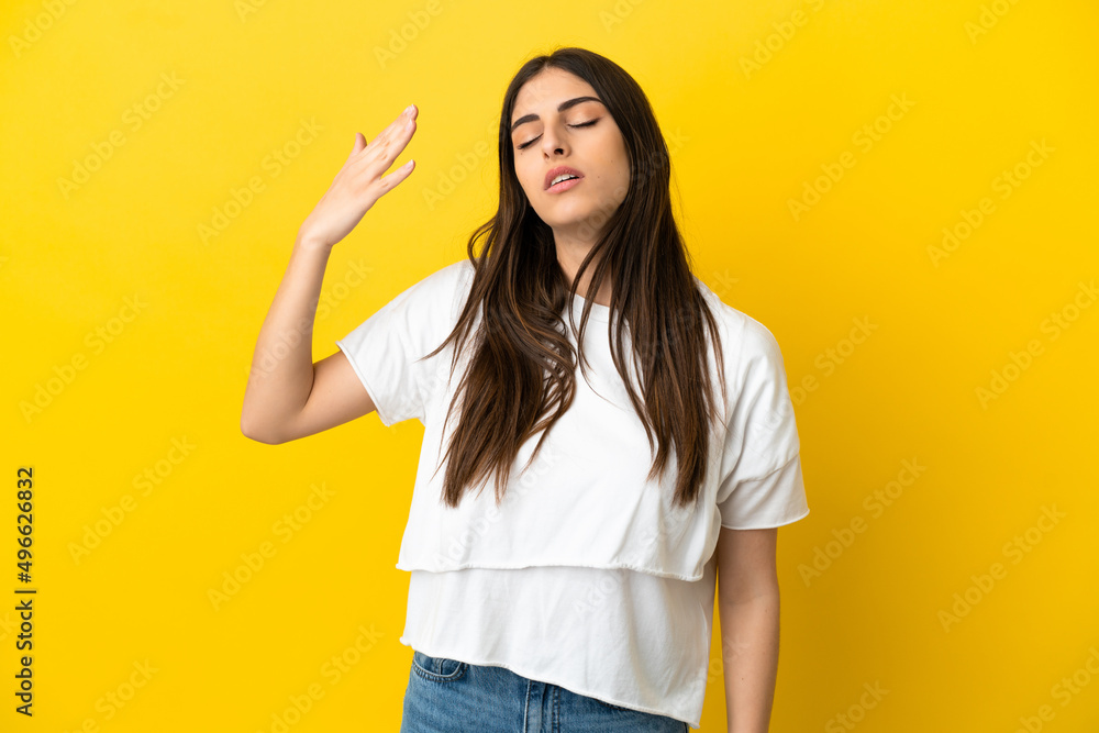Young caucasian woman isolated on yellow background with tired and sick expression Young caucasian woman isolated on yellow background with tired and sick expression