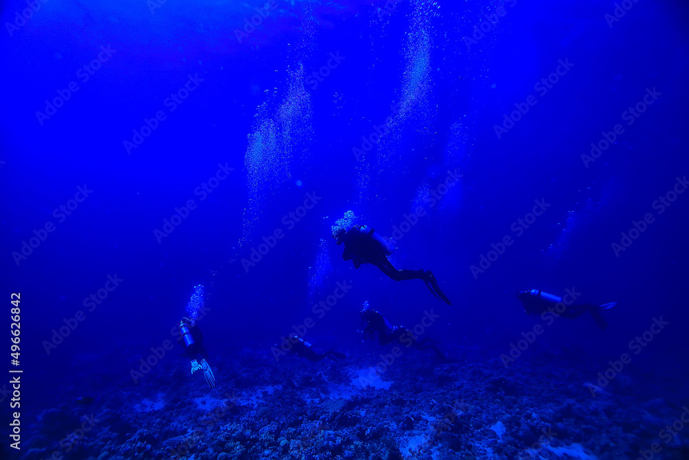 divers underwater at depth in the blue sea background divers underwater at depth in the blue sea background