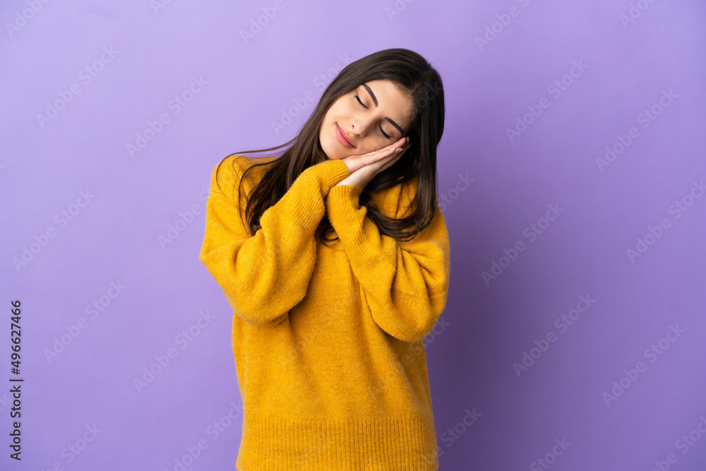 Young caucasian woman isolated on purple background making sleep gesture in dorable expression Young caucasian woman isolated on purple background making sleep gesture in dorable expression