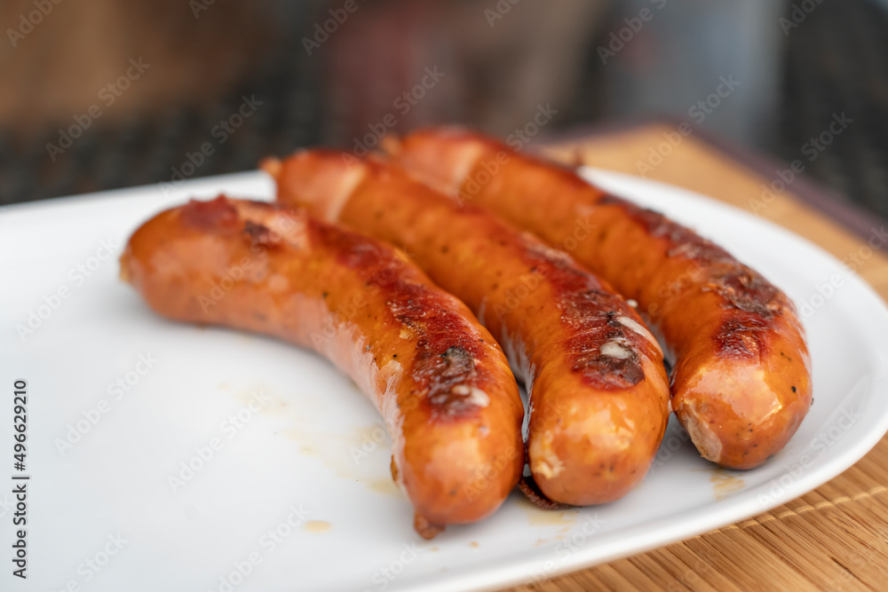 Burned Juicy sausage barbecue Sizzle on with Salt and Black Peppers on White Plate for Lunch BBQ Grilled for Picnic Burned Juicy sausage barbecue Sizzle on with Salt and Black Peppers on White Plate for Lunch BBQ Grilled for Picnic