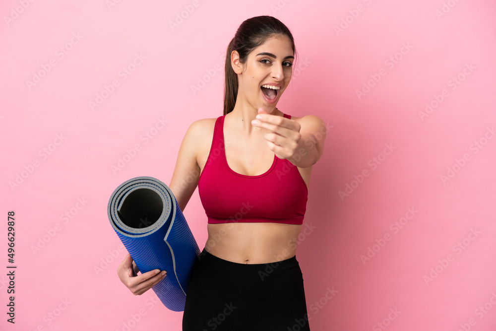 Young sport caucasian woman going to yoga classes while holding a mat making money gesture Young sport caucasian woman going to yoga classes while holding a mat making money gesture